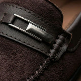 Mocassim de Camurça Titan Coffee: detalhe da ferragem retangular prateada, da faixa frontal e da textura marrom-escura.