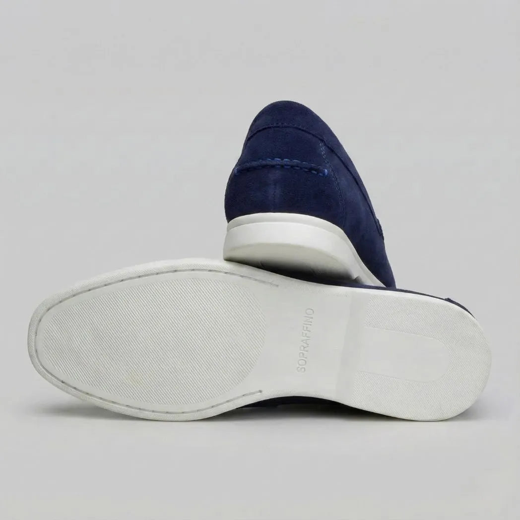 Mocassim de Camurça de Lebre: par azul-escuro com um sapato virado, mostrando a sola branca.