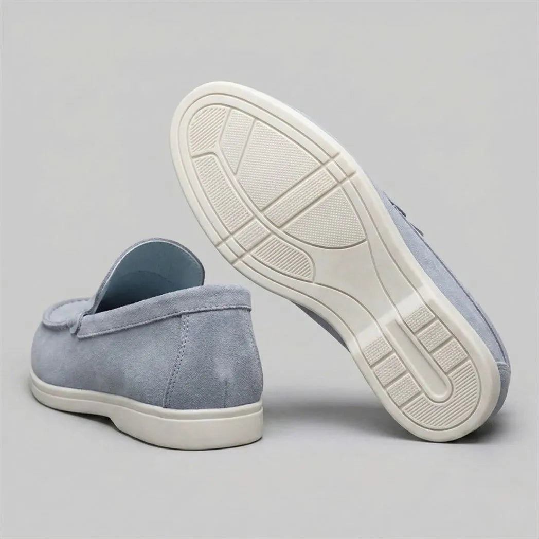 Mocassim de Camurça: par azul-claro com um sapato virado, mostrando a sola branca.