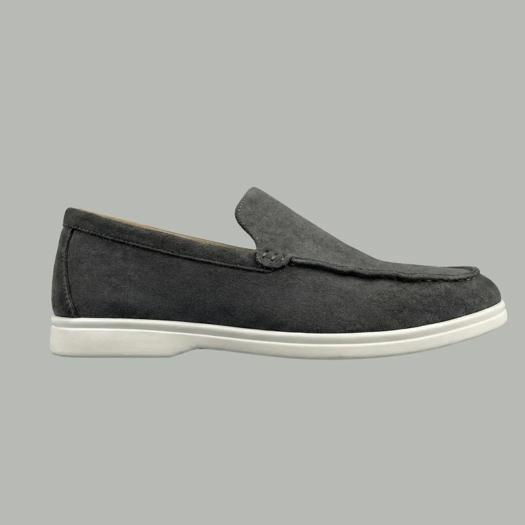 Mocassim de Camurça: modelo cinza de perfil, com sola branca.