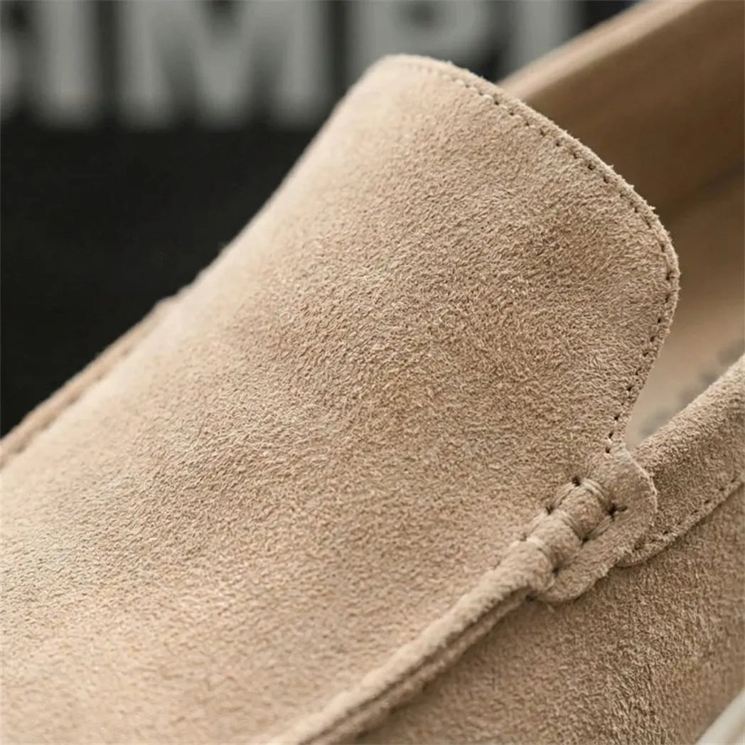 Mocassim de Camurça: detalhe da textura bege e da costura na parte frontal.