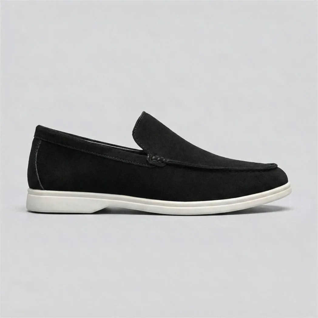 Mocassim de Camurça: modelo preto de perfil, com sola branca.
