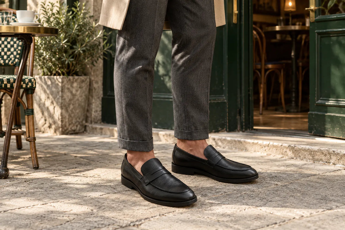 Mocassins Louford de couro preto usados com alfaiataria na entrada de um café