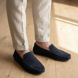 Mocassim Driver de Camurça Capri Tobacco escuro usado com calça clara de barra dobrada.